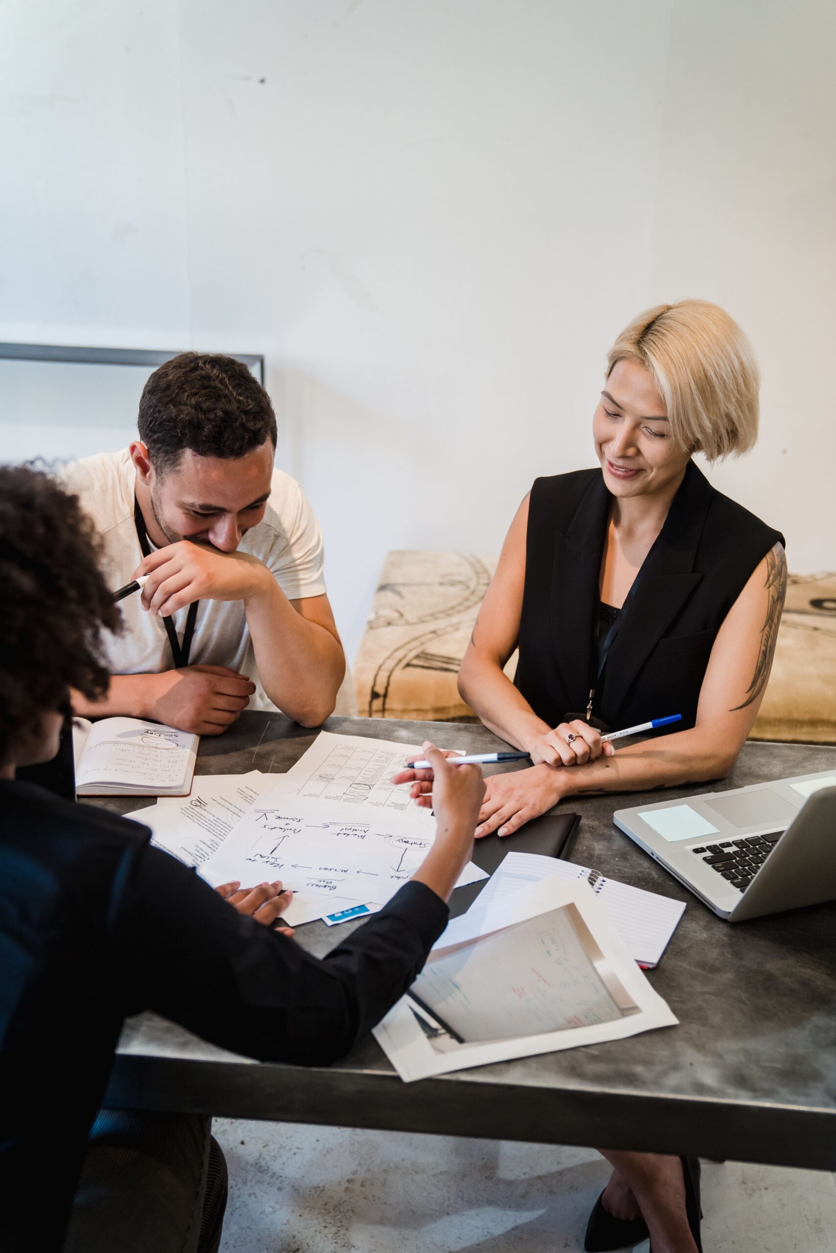 Group of professionals engaged in a collaborative meeting, planning strategies around a table in office setting.