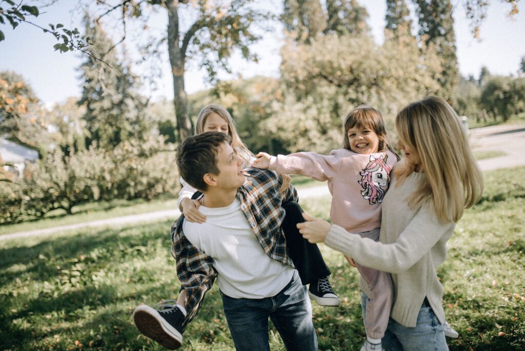 A joyful family spending quality time together in a green park on a sunny day.